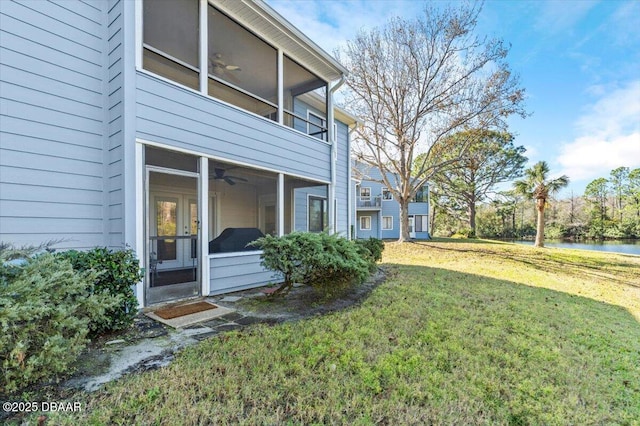 view of yard featuring a balcony, a sunroom, and ceiling fan