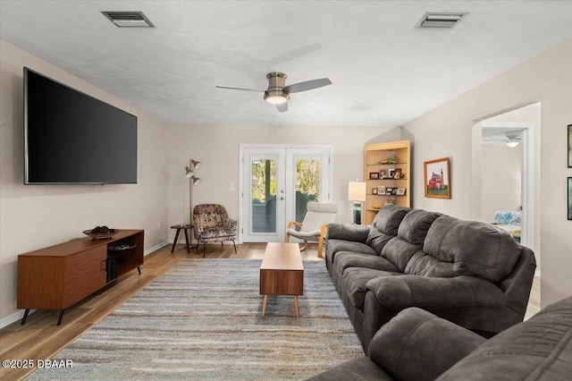 living room with french doors, ceiling fan, and wood-type flooring