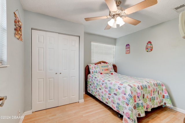 bedroom featuring light wood-type flooring, ceiling fan, and a closet