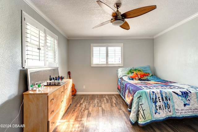 bedroom featuring a textured ceiling, hardwood / wood-style flooring, ceiling fan, and crown molding