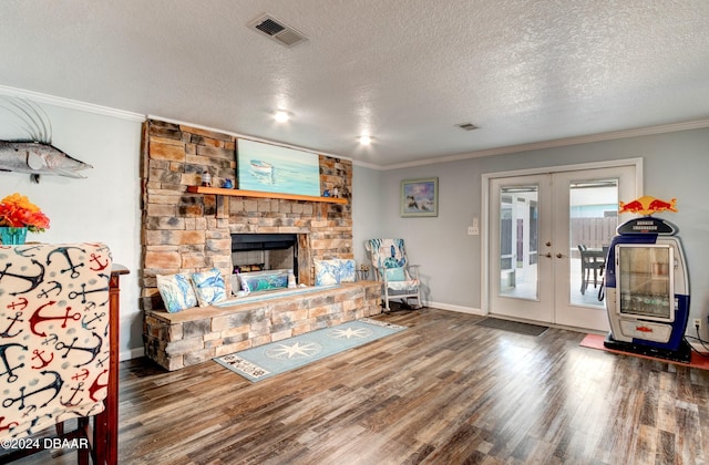 living room with dark wood-type flooring, a stone fireplace, french doors, and a textured ceiling