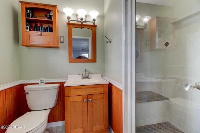 bathroom featuring wood walls, tile patterned flooring, vanity, an enclosed shower, and toilet