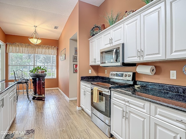 1840 Tara Marie Ln, Port Orange, FL 32128 - kitchen with appliances with stainless steel finishes, white cabinetry, baseboards, light wood-type flooring, and hanging light fixtures