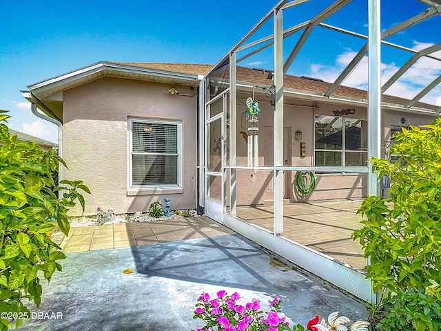 1840 Tara Marie Ln, Port Orange, FL 32128 - view of home's exterior featuring stucco siding, glass enclosure, a patio area, and a shingled roof