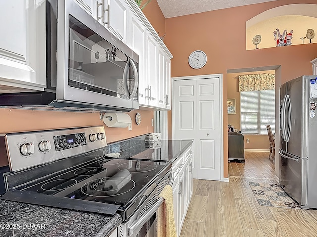 1840 Tara Marie Ln, Port Orange, FL 32128 - kitchen featuring appliances with stainless steel finishes, white cabinets, light wood-type flooring, and baseboards