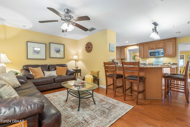 living room with ceiling fan and hardwood / wood-style floors