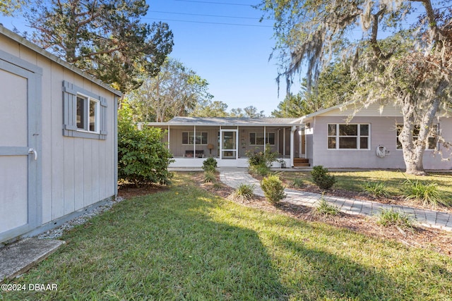 view of front of house with a sunroom and a front lawn