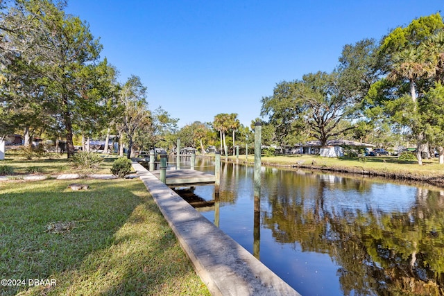 dock area with a lawn and a water view