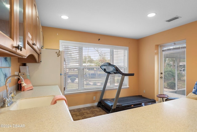 exercise area with dark parquet flooring and sink