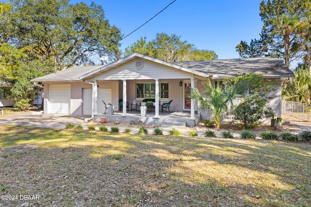 view of front of home featuring a garage, covered porch, and a front lawn