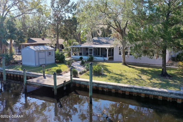 view of dock featuring a water view and a yard