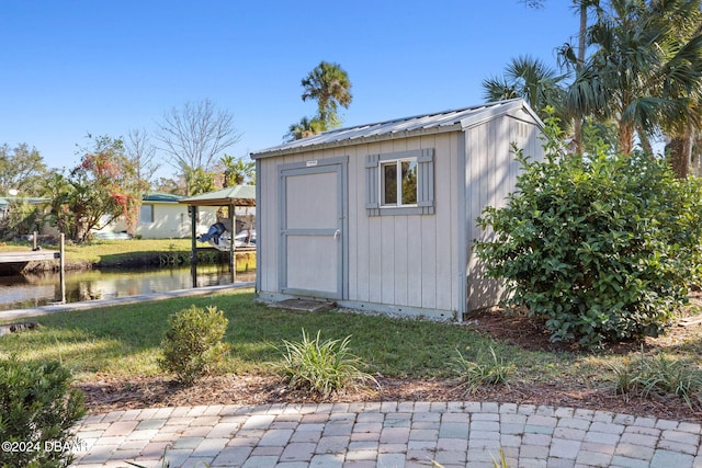 view of outdoor structure featuring a water view and a yard