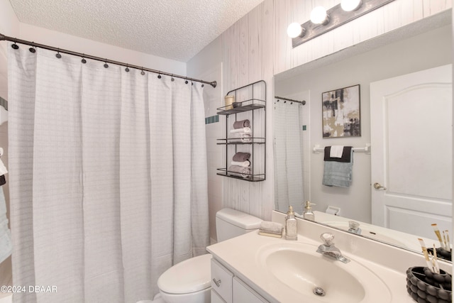 bathroom with a shower with curtain, vanity, a textured ceiling, and toilet