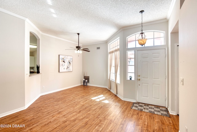 entrance foyer with light hardwood / wood-style floors, a healthy amount of sunlight, and ornamental molding