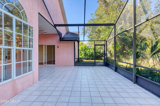 unfurnished sunroom with ceiling fan