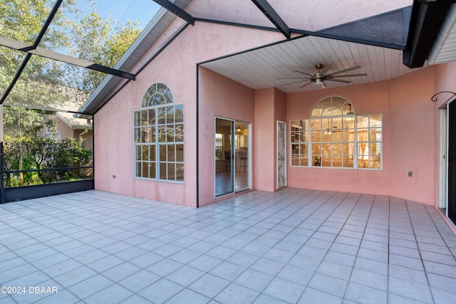 unfurnished sunroom featuring a wealth of natural light, ceiling fan, and lofted ceiling with beams