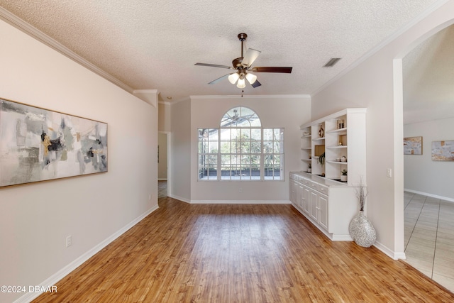 unfurnished living room featuring a textured ceiling, light hardwood / wood-style flooring, ceiling fan, and crown molding