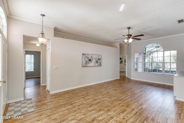 empty room featuring ceiling fan, light wood-type flooring, crown molding, and a wealth of natural light