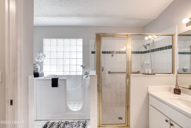 bathroom featuring a textured ceiling, vanity, tile patterned flooring, washer / clothes dryer, and a shower with shower door