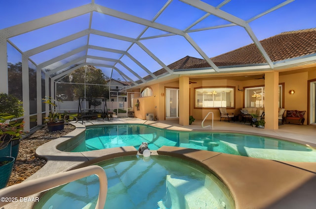 view of pool featuring a lanai, a patio area, and ceiling fan