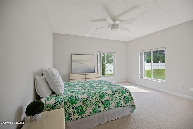 carpeted bedroom with ceiling fan and a textured ceiling