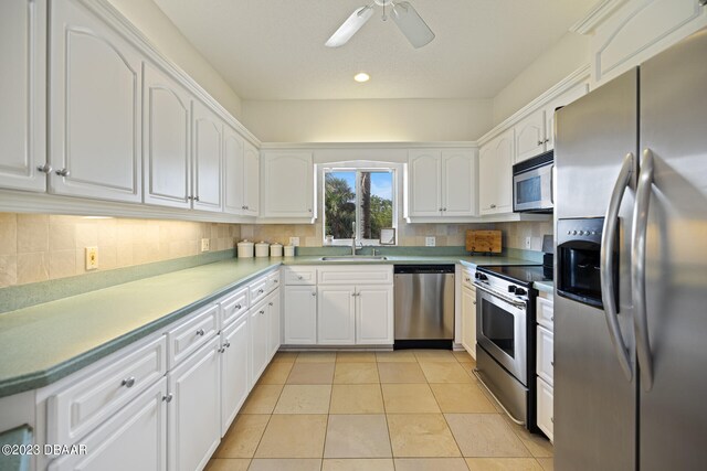 kitchen featuring tasteful backsplash, white cabinetry, light tile patterned floors, and stainless steel appliances