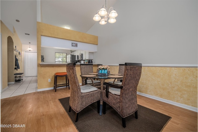 2953 Wild Pecan Ct, Port Orange, FL 32129 - dining area featuring light wood finished floors, a chandelier, lofted ceiling, and arched walkways