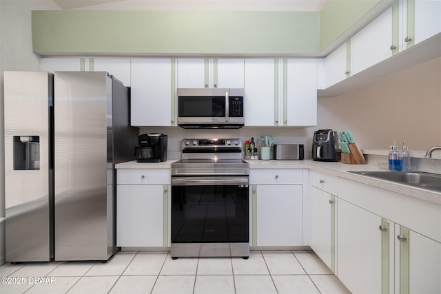 2953 Wild Pecan Ct, Port Orange, FL 32129 - kitchen with appliances with stainless steel finishes, light countertops, white cabinetry, and light tile patterned floors