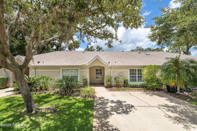 2953 Wild Pecan Ct, Port Orange, FL 32129 - ranch-style house with stucco siding, a front lawn, and roof with shingles
