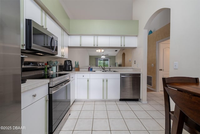 2953 Wild Pecan Ct, Port Orange, FL 32129 - kitchen with appliances with stainless steel finishes, light countertops, white cabinetry, light tile patterned floors, and a high ceiling