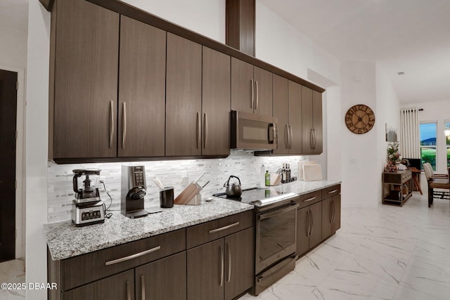 6294 W Fallsgrove Ln, Port Orange, FL 32128 - kitchen featuring stainless steel microwave, black electric range, light marble finish flooring, decorative backsplash, and dark brown cabinets