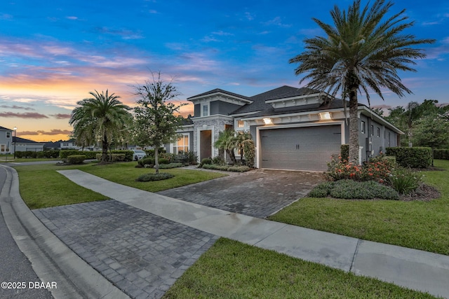 6294 W Fallsgrove Ln, Port Orange, FL 32128 - view of front of property featuring a front yard, decorative driveway, stucco siding, an attached garage, and stone siding