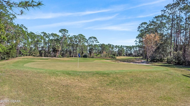 view of property's community featuring golf course view and a yard