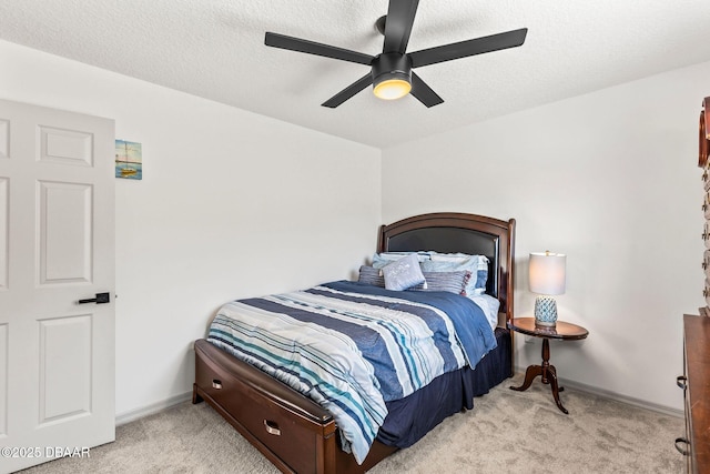 bedroom with light carpet, ceiling fan, a textured ceiling, and baseboards