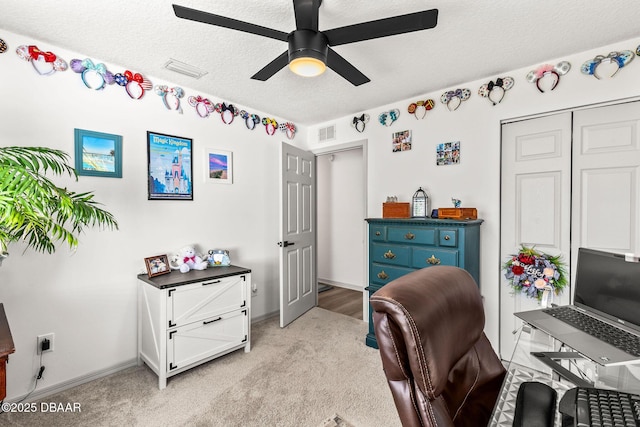 office area with light colored carpet, visible vents, ceiling fan, a textured ceiling, and baseboards