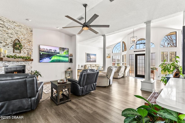 living room featuring a fireplace, decorative columns, and a ceiling fan