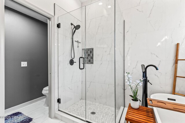 full bathroom featuring toilet, marble finish floor, a shower stall, and baseboards