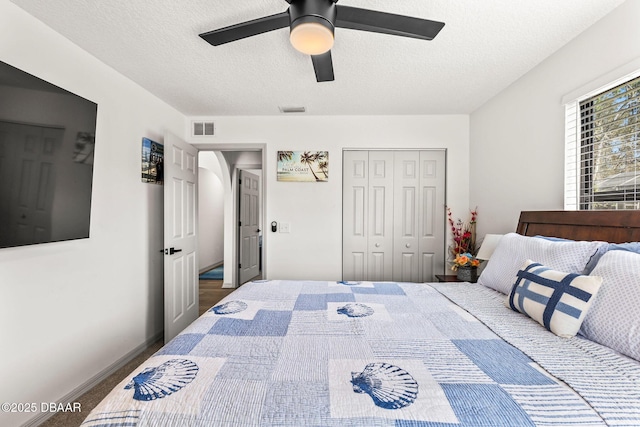 bedroom featuring a ceiling fan, a closet, visible vents, and a textured ceiling