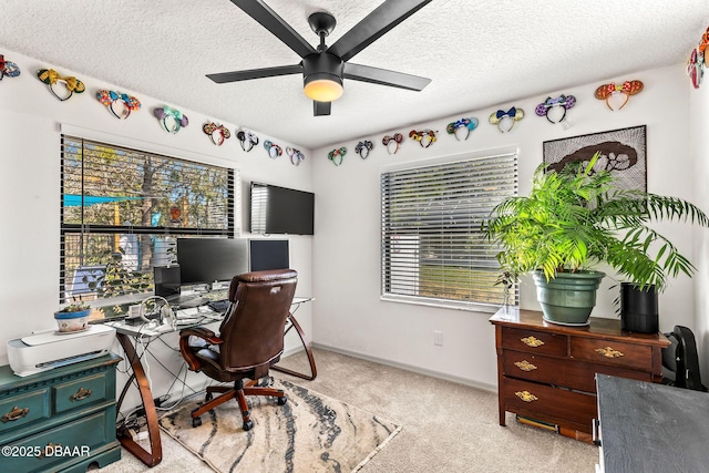 office space featuring light carpet, ceiling fan, a textured ceiling, and baseboards