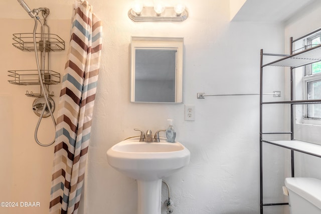 bathroom with toilet and curtained shower