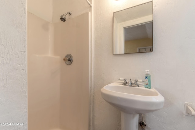 bathroom featuring walk in shower and sink