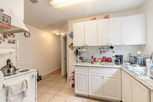 kitchen featuring light stone countertops, white appliances, white cabinetry, and light tile patterned floors