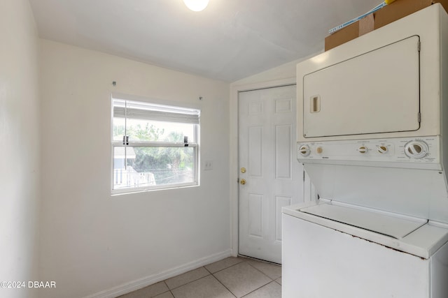 laundry room with light tile patterned flooring and stacked washer and clothes dryer