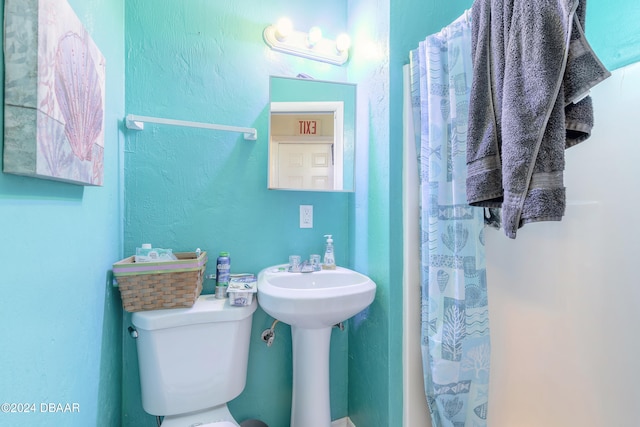 bathroom featuring a shower with curtain and toilet