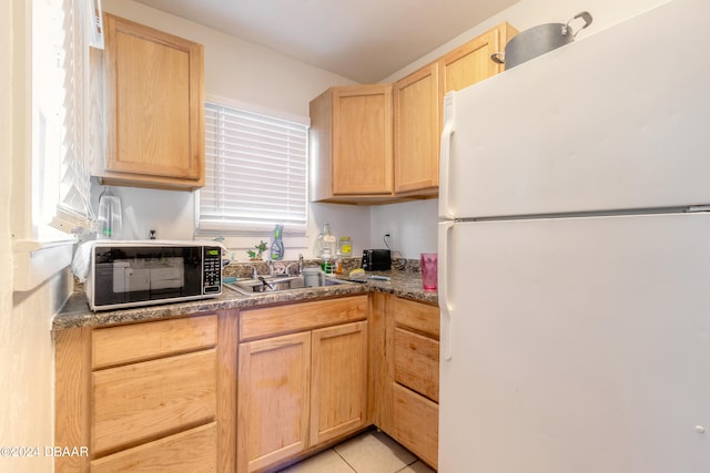 kitchen featuring light brown cabinets, light tile patterned floors, and white refrigerator