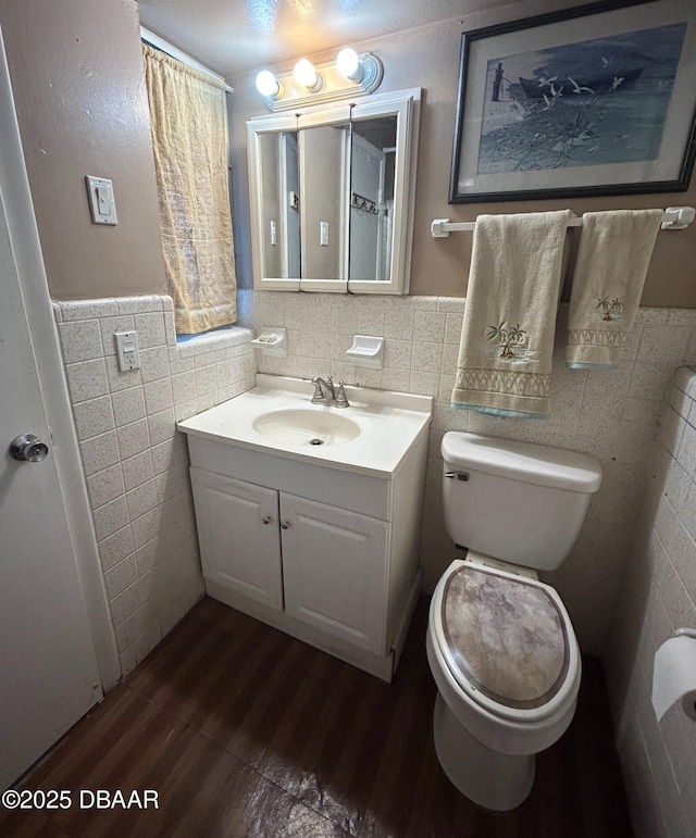 bathroom featuring tile walls, toilet, vanity, and hardwood / wood-style floors