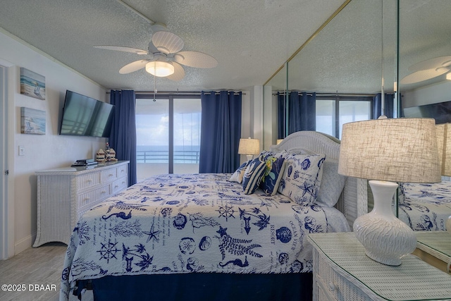 bedroom with floor to ceiling windows, a textured ceiling, and ceiling fan