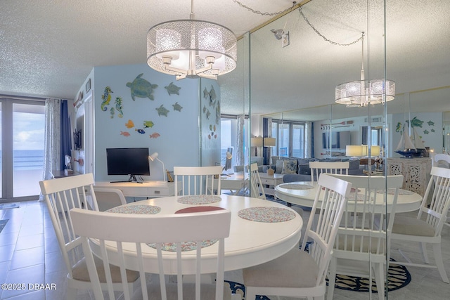 dining area featuring tile patterned floors, a chandelier, and a textured ceiling