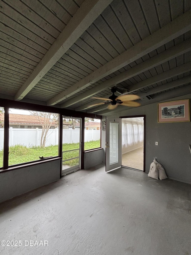 unfurnished sunroom featuring beamed ceiling, a water view, and ceiling fan