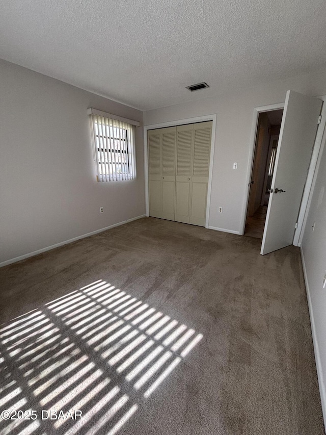 unfurnished bedroom featuring carpet floors, a closet, and a textured ceiling